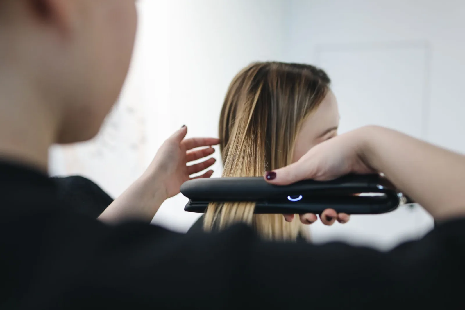 A stylist straightening a client's hair