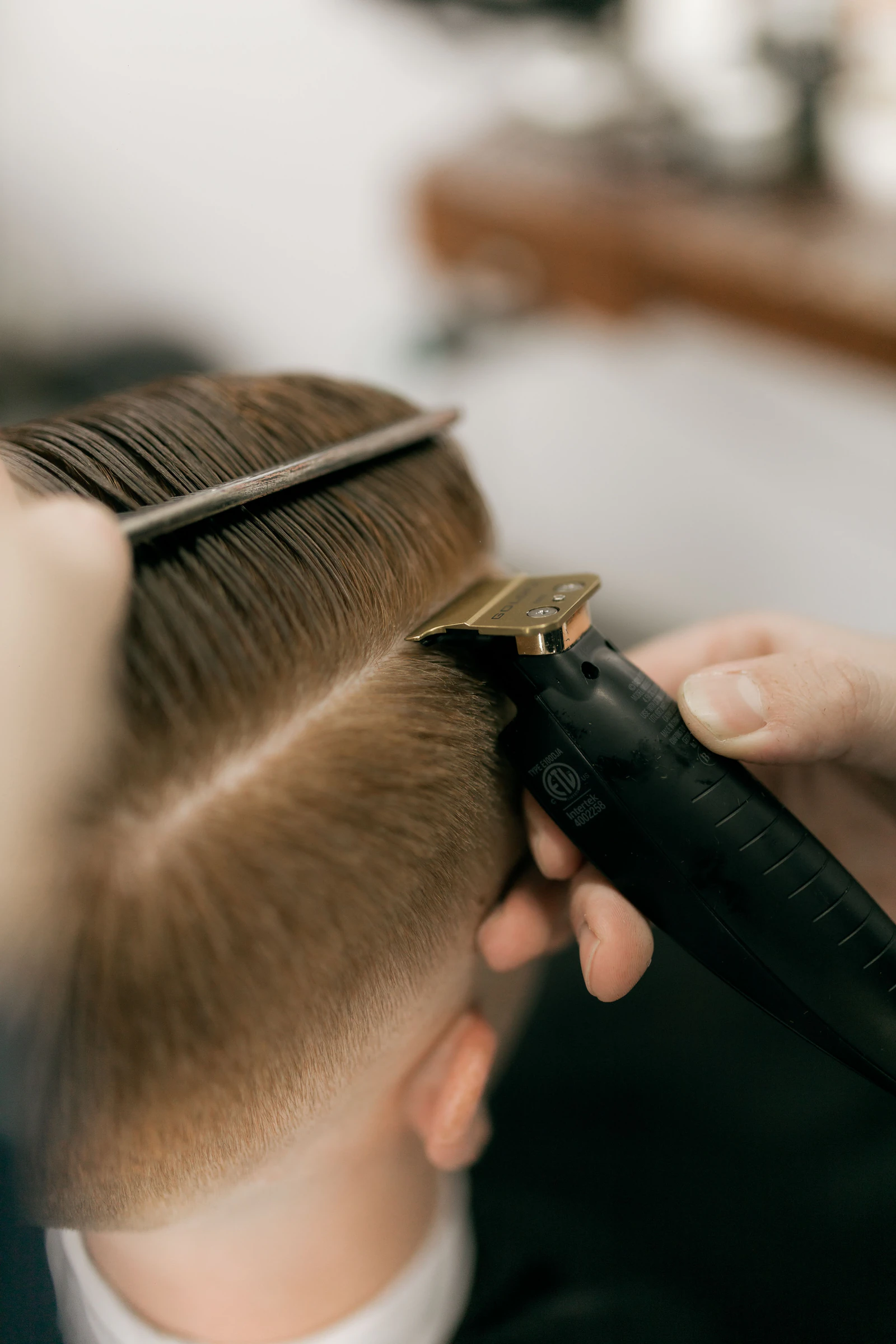 A barber fading the side of a client's head with clippers